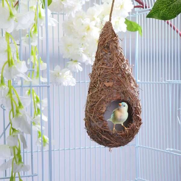 Cuatro casas de colibrí tejidas a mano con paja natural, colgando de una rama en un jardín.