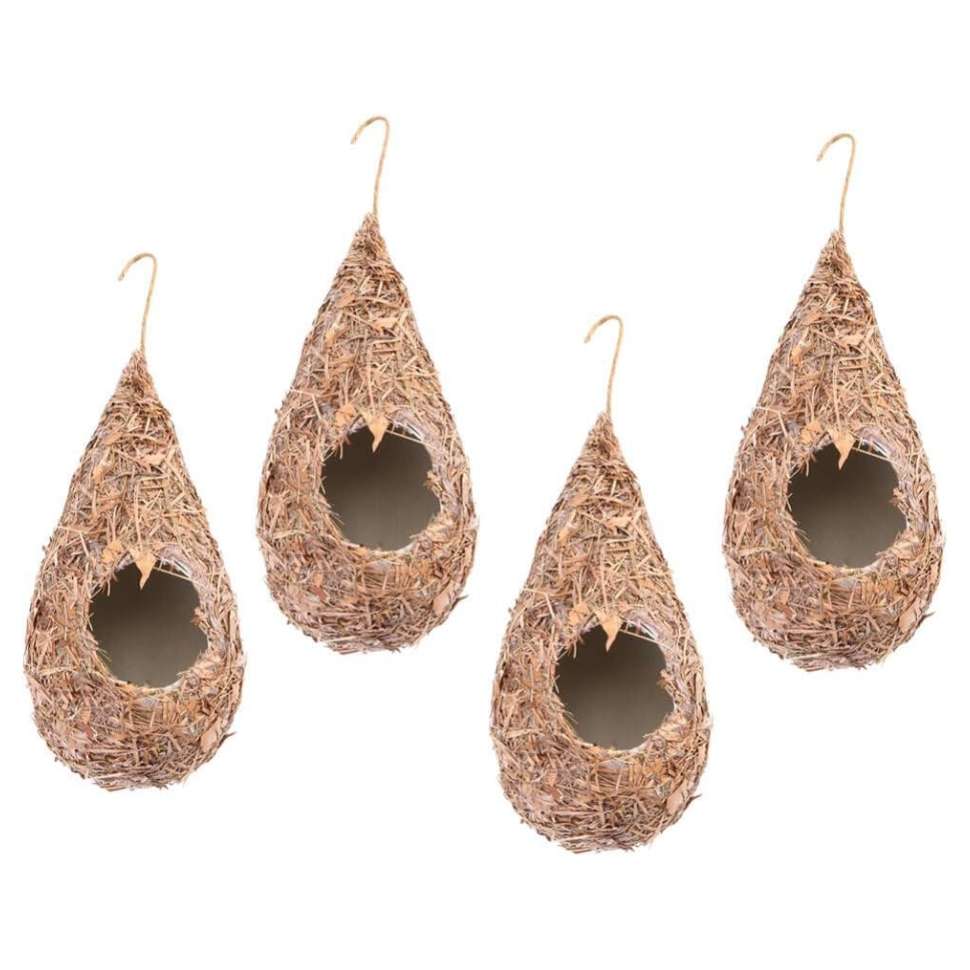 Cuatro casas de colibrí tejidas a mano con paja natural, colgando de una rama en un jardín.
